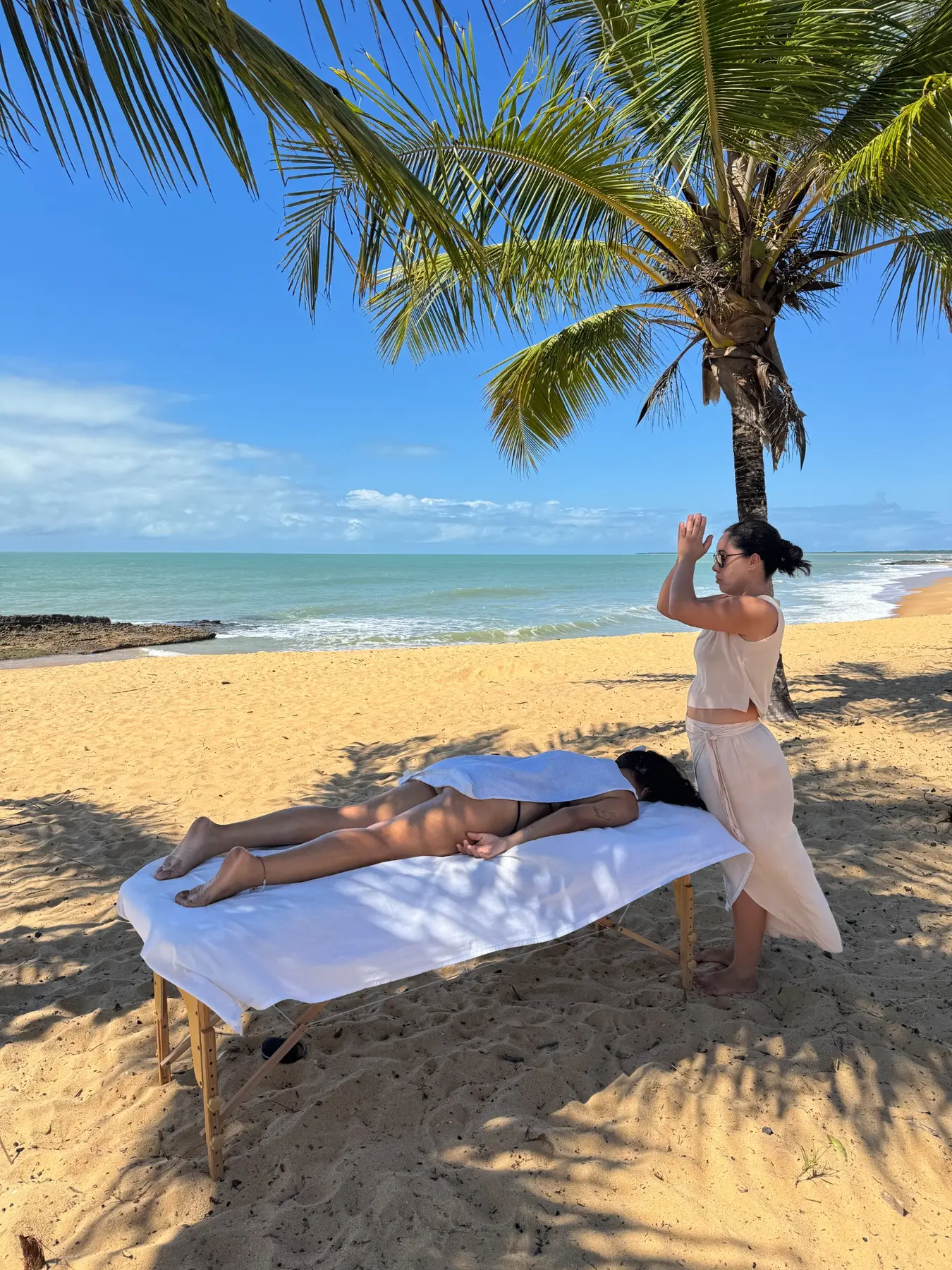 Bruna Krasucki realizando uma massagem na praia em Caraíva